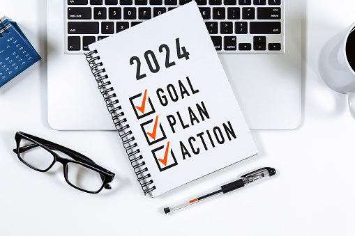 2024 Objetivo, Plan, Lista de verificación de acción Texto en el bloc de notas con computadora portátil, gafas y bolígrafo. photo