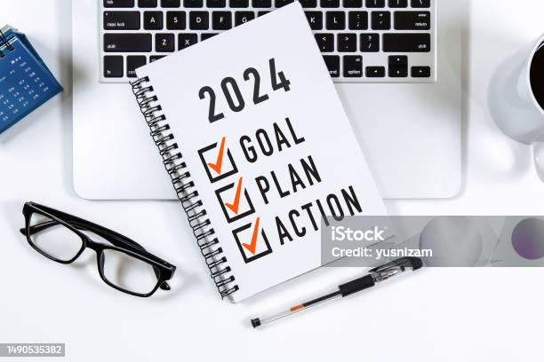 2024 Goal Plan Action Checklist Text On Note Pad With Laptop Glasses And Pen Stock Photo - Download Image Now