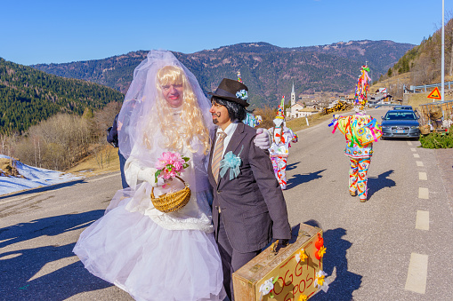 Valfloriana, Italy - February 26, 2022: Carnival participants costumed as bride and groom, in the Valfloriana carnival, Trentino, Northern Italy