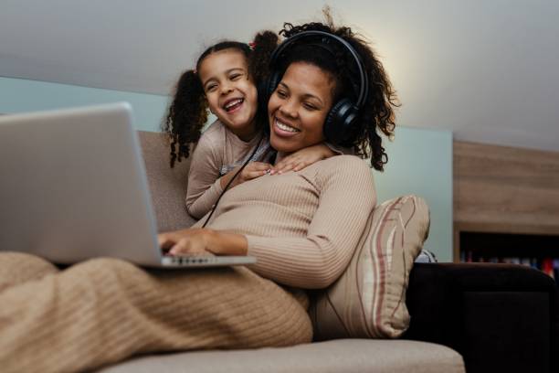 istock Creative black mother and daughter working on school project, using modern laptop 1490539878