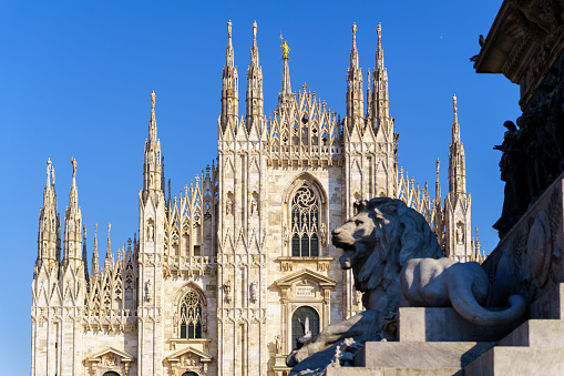 Milan, Italy - March 03, 2022: View of the Cathedral (Duomo) facade, and the Statue for Vittorio Emanuele II (dated 1879) in the foreground, in Milan, Lombardy, Northern Italy
