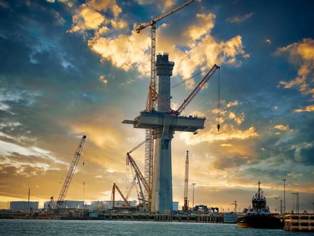 istock Large crane perched atop a high-rise construction building overlooking the ocean. 1490541986