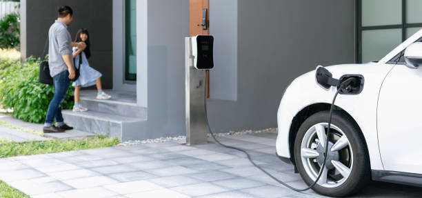 istock Progressive dad and daughter charging EV car from home charging station. 1490549503