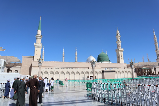 The famous Green Dome of the Holy Prophet's Mosque or Masjid Nabawi. Muslim pilgrims on the courtyard on Masjid Nabawi in Medina, Saudi Arabia. 02/03/2023