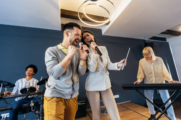 istock Business people making team training exercise during team building seminar singing karaoke. 1490550643