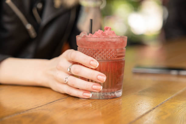 istock Woman hand holding red cocktail glass with ice. 1490551401