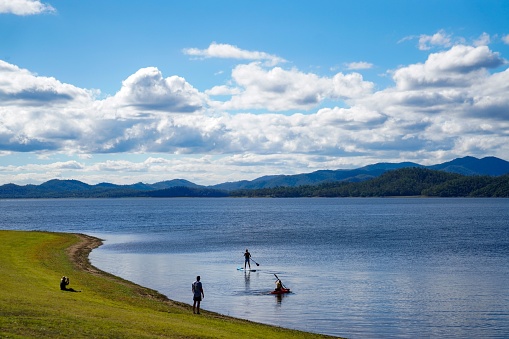 A young adult paddling a canoe on a tranquil lake in Brisbane, Australia