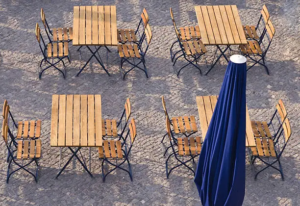 Tables and chairs on a street terrace in a city.