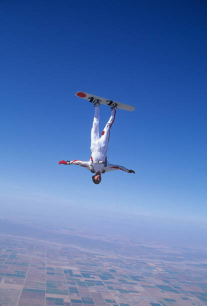 fallschirmspringer surft auf einem skyboard durch die luft - skydiving air aerial view vertical stock-fotos und bilder