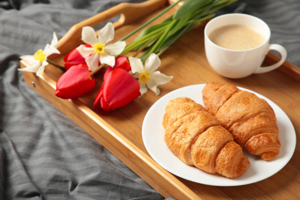 istock Breakfast in bed with coffee, croissants and tulip on tray 1490560767