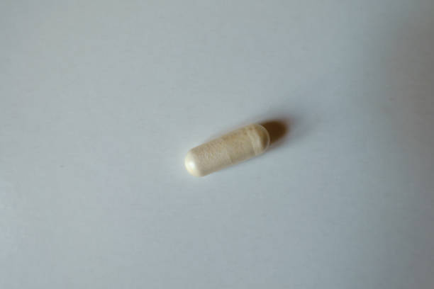 istock Single light beige capsule of probiotic dietary supplement 1490561769