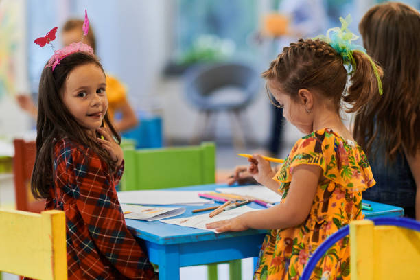 istock Creative kids during an art class in a daycare center or elementary school classroom drawing with female teacher. 1490563449