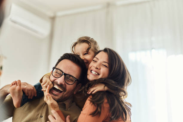 niña alegre divirtiéndose con sus padres en casa. - happy family home fotografías e imágenes de stock