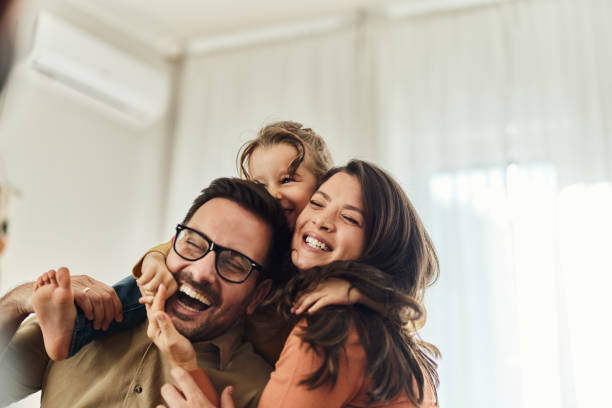 cheerful girl having fun with her parents at home. - geluk stockfoto's en -beelden