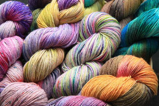 Multiple skeins of colourful handdied sock yarn, sock wool, with extreme vibrant colours for knitting socks and other craft projects as a hobby.