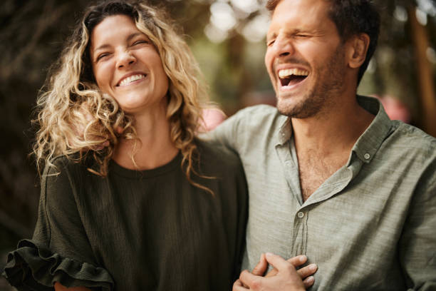 Cheerful couple laughing in nature.