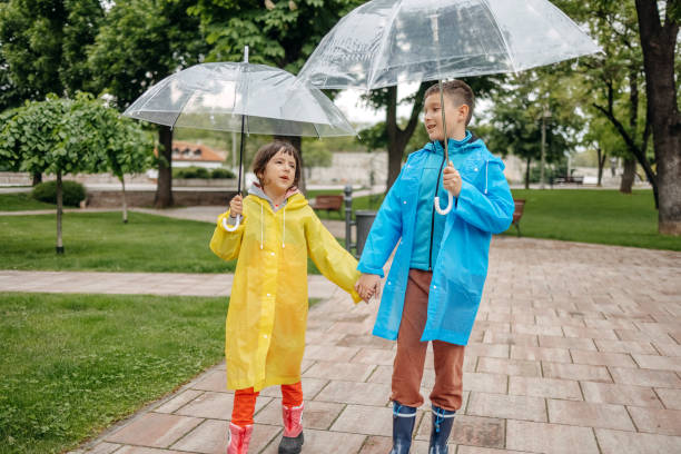 istock Kids outside with umbrellas playing on rainy day 1490567898