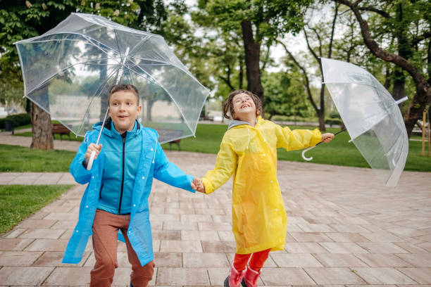 istock Kids outside with umbrellas playing on rainy day 1490567933