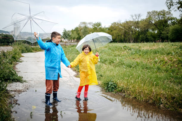 istock Kids playing in water puddle on cloudy day 1490568097