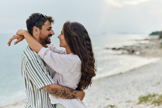 istock Happy couple in love talking on the beach. 1490568416
