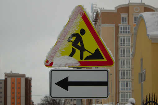 Road construction sign with snow on it. Winter roadworks