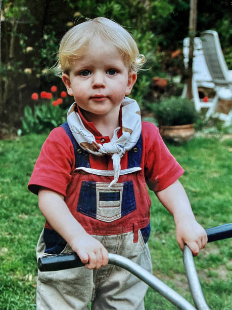 Toddler boy helping in the garden back in time