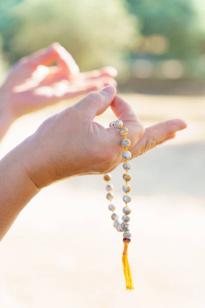 istock woman's hands holding a Buddhist mala in prayer 1490570587