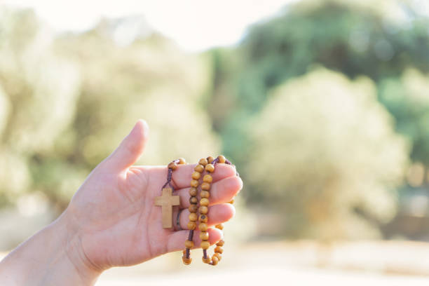 istock woman's hands holding a christian rosary with a cross 1490570588