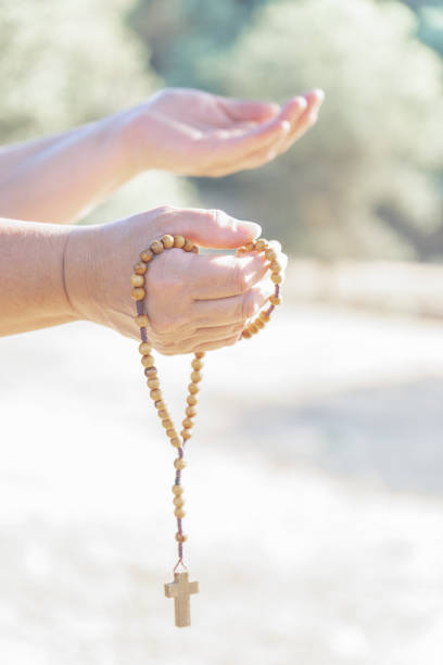 istock woman's hands holding a christian rosary with a cross 1490570616