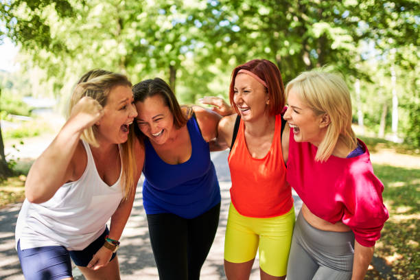 freundinnen, die spaß beim lachen nach outdoor-übungskurs im park im sommer haben - sports clothing jogging running 40s stock-fotos und bilder