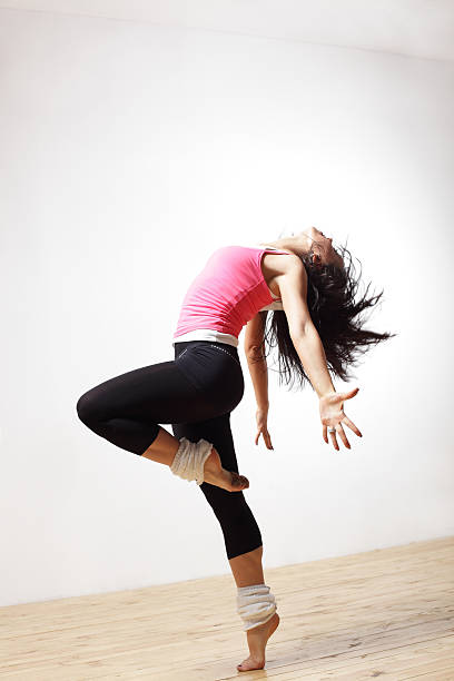 Women in leg warmers bends backwards while dancing modern style dancer posing on studio background jazz dancing stock pictures, royalty-free photos & images