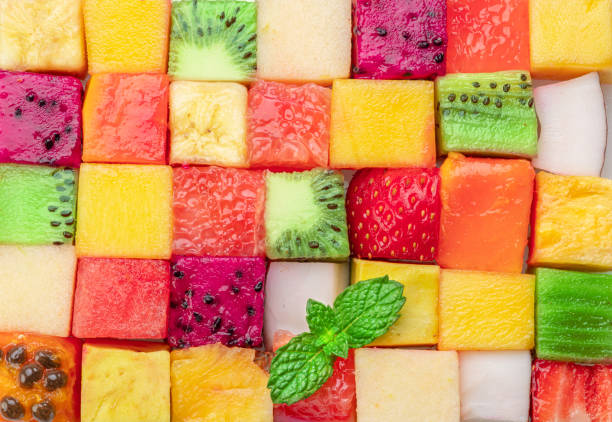 istock Fruit puzzle. Colorful food background or pattern arranged of different fruit cubes. Dietary concept. 1490578635