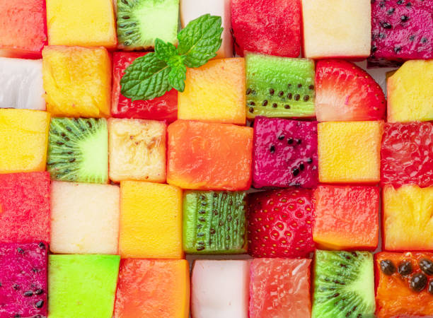 istock Fruit puzzle. Colorful food background or pattern arranged of different fruit cubes. Dietary concept. 1490578677