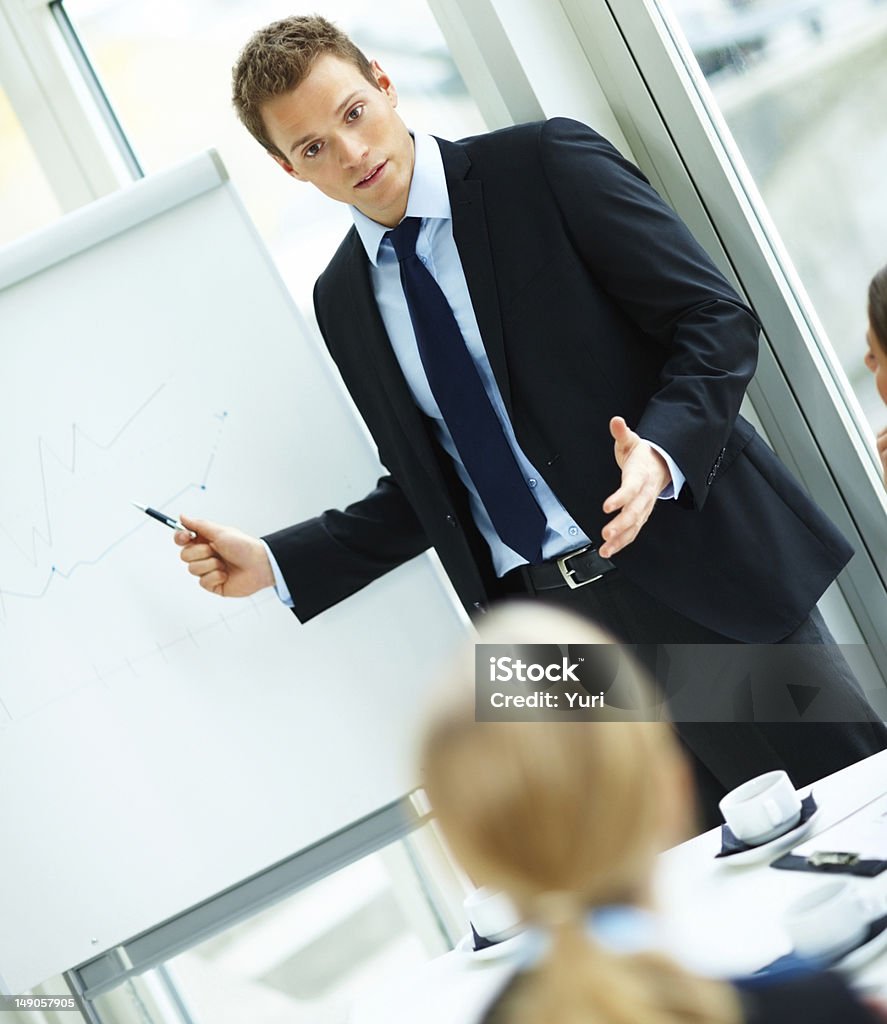 Business man giving a presentation Young business man giving a presentation in office Men Stock Photo