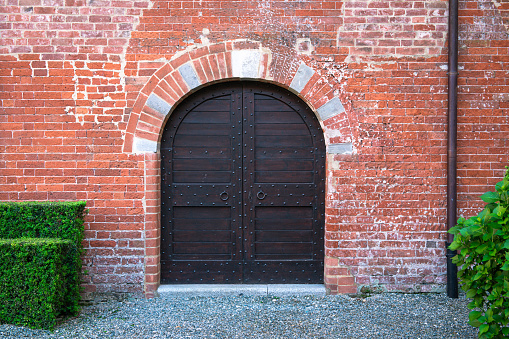 Ancient wooden arched door of medieval house