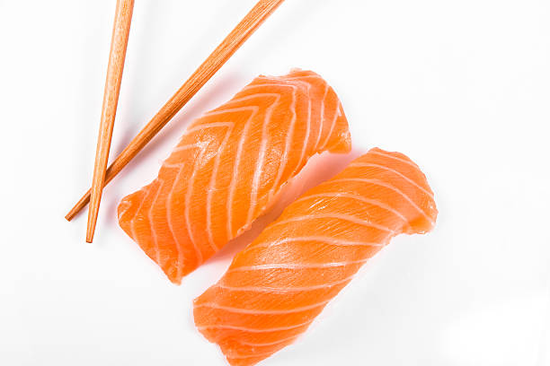 zwei stücke von lachs nigiri, mit stäbchen - sake nigiri stock-fotos und bilder