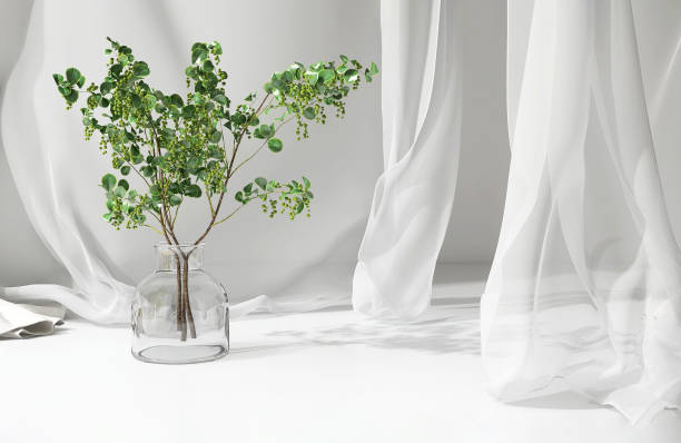 istock Empty white counter table, soft, smooth blowing sheer fabric curtain drapery, tree branch glass vase in sunlight 1490583752