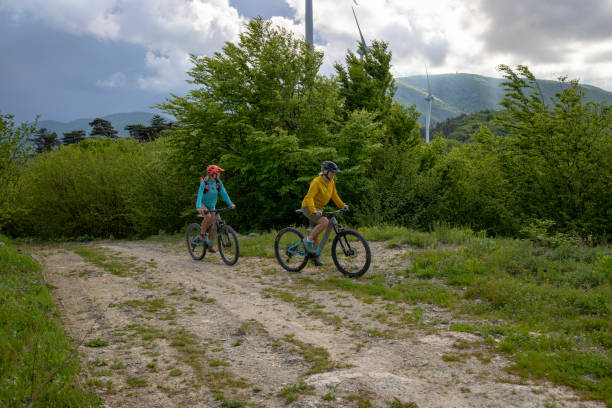 istock Mother and daughter e-bike below wind turbines 1490586797
