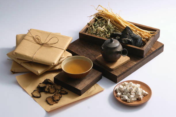 TRADITIONAL MEDICINE A dish of Poria cocos, Szechuan Lovage Rhizome, a medicine bowl and earthen pot putted on a podium, displayed with a tray of some herbs. Herbal medicine can help improve the overall health codonopsis pilosula stock pictures, royalty-free photos & images