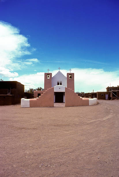 Francis of Assisi Chapel, Taos, circa 1976 St. Francis of Assisi chapel in Taos, prior to all the construction that has encircled it in the last 30 years. Abundant copy space above (in the sky) and below (on the dirt/gravel pavement). hearkencreative stock pictures, royalty-free photos & images