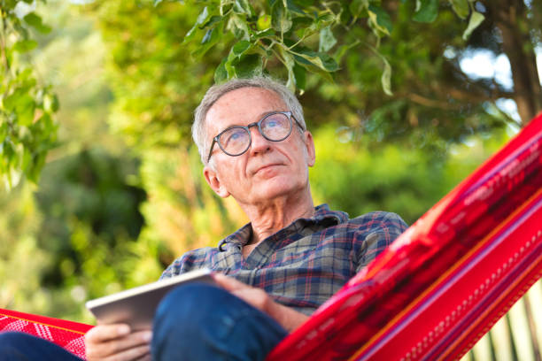 istock Contemplative senior man wearing eyeglasses sitting on hammock 1490593028