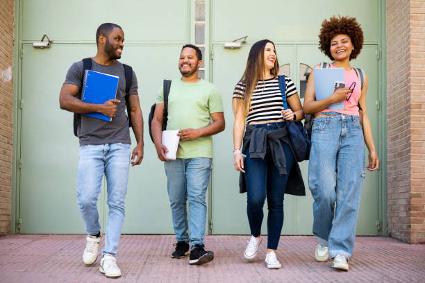istock A diverse group of casually dressed college students. The 4 young people leave the university door with textbooks and backpacks. Concept of rest between classes, recess, change of class. 1490593103