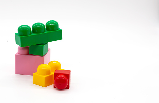 Children's construction kit in different colors and sizes. Red, pink and yellow and green blocks. Photo in high quality. Isolated.