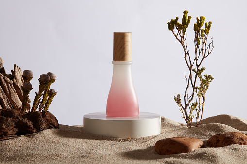A circle podium in white color with a pink and white gradient jar standing on. Desert concept. Empty label for product mockup