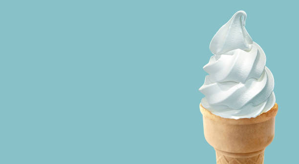 cornet de crème glacée en gros plan dans un cône de gaufres sur fond bleu - soft serve ice cream photos et images de collection
