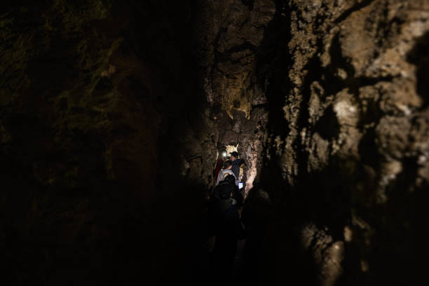 istock Family tourists walking in cave and explore it. 1490599828
