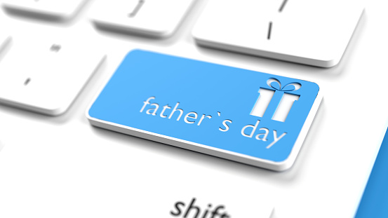 Father's Day gift box icon and text on a blue button of a computer keyboard. Horizontal composition with selective focus and copy space. High angle view. Father's Day concept. Easy to crop for all your social media and print sizes.