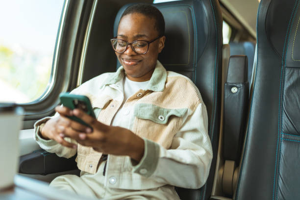 istock A young African-American girl rides a train and using a mobile phone. Train ride. 1490601328