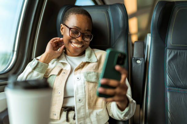 istock A young African-American girl rides a train and using a mobile phone. Train ride. 1490601347
