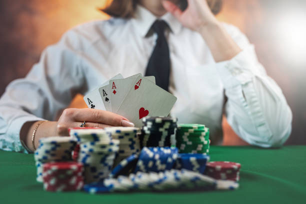 istock Female hand holding playing cards and chips at a round poker table. 1490601972